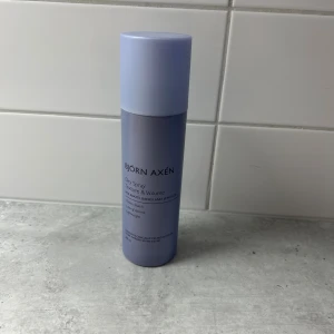 Björn Axén Dry Spray Texture & Volume - En lila sprayflaska från Björn Axén med textur- och volymspray för håret. Produkten är vegansk och dermatologiskt testad, perfekt för att ge extra volym och struktur till rötter, längder och lugg.