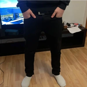 Replay Anbass svarta jeans - Svarta jeans från Replay, modell Anbass. Slim fit med normal passform och klassisk femficksdesign. Jeansen har en snygg, mörk ton och är tillverkade i stretchigt jeansmaterial för extra komfort. Perfekt för dig som gillar stilrena och moderna byxor.