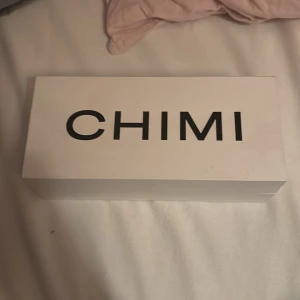 Grå transparenta solglasögon CHIMI - Snygga solglasögon från CHIMI med transparent grå båge och fyrkantig form. Kommer i originalfodral och box. Glasen är mörka och ger en cool vibe, perfekt för dig som gillar stilrena accessoarer med modern touch.