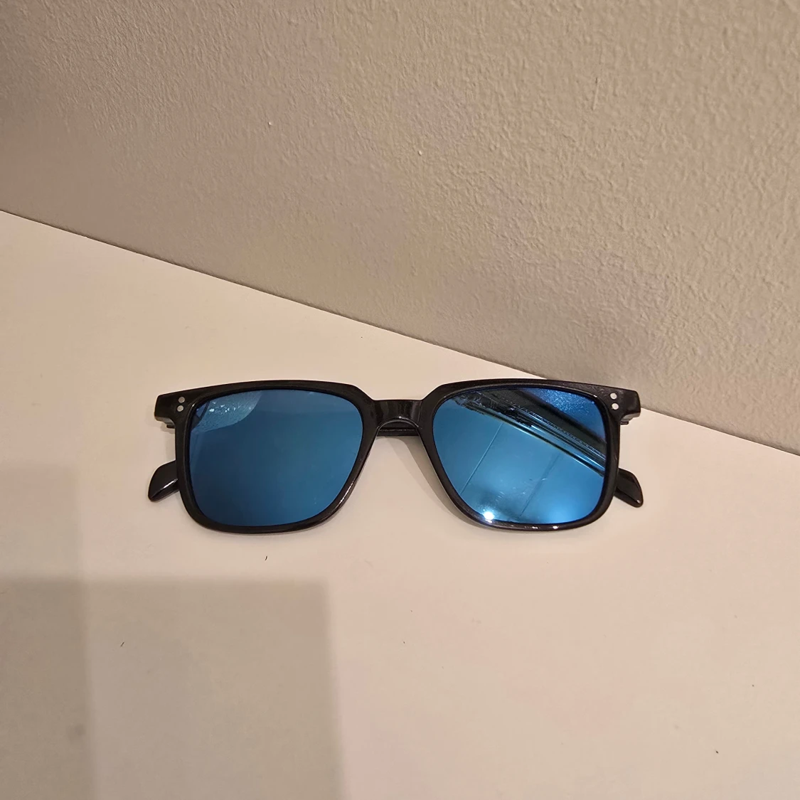 Svarta solglasögon med blå spegelglas