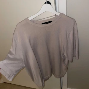 Beige stickad tröja - Säljer en beige stickad tröja med rund hals och korta ärmar. Tröjan har en enkel och clean design, perfekt för dig som gillar minimalistisk stil. Materialet är mjukt och skönt mot huden.