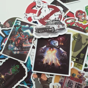 Ghostbusters Klistermärken Set - Ett färgstarkt set med 27 Ghostbusters-klistermärken i olika motiv, inklusive Ecto-1, Stay Puft Marshmallow Man och Slimer. Perfekt för att dekorera laptop, mobil eller anteckningsbok. Klistermärkena är i nyskick utan synligt slitage.