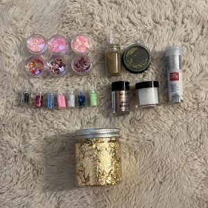 Stort kit med glitter och paljetter - Säljer ett stort kit med glitter och paljetter i olika färger och former, perfekt att ha på naglarna. Innehåller burkar med rosa, guld, silver och blått glitter, paljetter i hjärtan och stjärnor, samt ett stort glas med guld flakes. Märken som NYX och Knorr Prandell ingår.