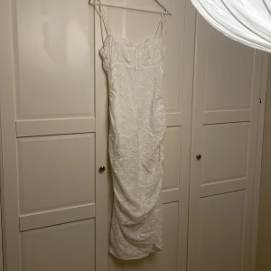 Vit blommig klänning med spetsdetaljer - Fin vit midiklänning. Storlek 40 men passar M