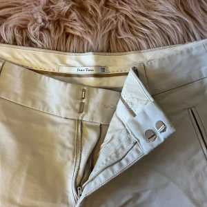 Beige byxor från Part Two - Snygga beige byxor från Part Two med dragkedja och knappstängning. Byxorna har en stilren design med raka ben och diskreta fickor fram. 