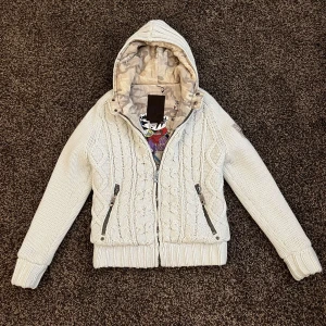 Stickad cardigan med camo fodring - Riktigt fet fodrad stickad cardigan med camo på insidan och inuti luvan vilket gör den både unik och väldigt stilig. Extremt bra passform och väldigt varm. Storlek S 