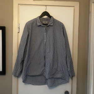 Randig skjorta från Hampton Republic - Snygg blå och vit randig skjorta från Hampton Republic i storlek XL. Skjortan har långa ärmar och knappar framtill. Perfekt för en stilren look.