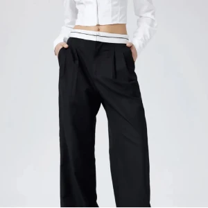 Svarta kostymbyxor  - Snygga svarta kostymbyxor med vida ben. Byxorna har ett fejk veck framtill. Aldrig använda