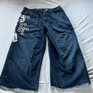 Tribal gear baggy jeans med tryck - Snygga jeans från tribal gear. Buda gjärna🙏🙏Längd:92cm Midja:40cm Benöppning:25cm. Har sytts upp vid botten för stt göra längre. Skriv för mer mått eller bilder👍👍👍👍