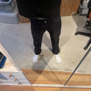 Svarta Levis 501 jeans - Säljer ett par klassiska svarta Levis 501 jeans. De har en rak passform och är tillverkade i slitstarkt denim. 