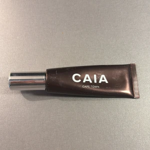 Bronzer från CAIA - Bronzer från CAIA i en stilren tub med texten 'CAPE TOWN'. Tuben har en metallisk kork och en mörkbrun färg. Perfekt för en jämn och naturlig look. Använd men finns ca 75% kvar i förpackningen. Lite märken på förpackningen pga den legat i sminkväskan 
