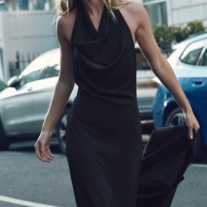 Svart långklänning med draperad hals - Elegant svart långklänning med en stilren draperad hals och öppen rygg. Helt ny , storlek xs