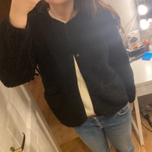 Svart teddyjacka - Mysig svart teddyjacka från HM med knappar framtill. Den är knappt använd, skriv om mer bilder 