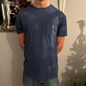 Polo Ralf Lauren Classic Fit Jersey pocket T-Shirt  - En Blå polo T-shirt i blå! Storlek S men relativt stor i storleken! Använd 3-4 gånger & Säljer på grund av att jag ej kommer använda den frammöver! 
