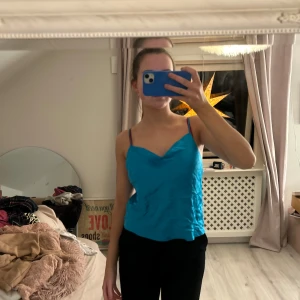 Blå linnetopp från Intimissimi - Säljer en snygg blå linnetopp från Intimissimi. Toppen har smala axelband och en enkel design som passar perfekt för sommardagar. Perfekt för att styla med jeans eller kjol.