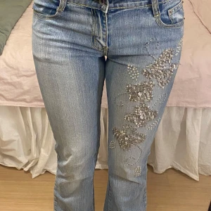 Bootcut jeans - Lågmidjade bootcut jeans med paljetter i blommönster på benet😚