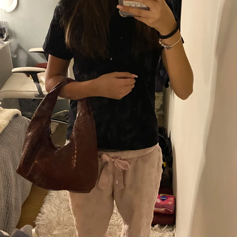 Snygg Vinröd axelväska med ett ormskinnsmönster. Perfekt för att ge din outfit en trendig touch. Väskan har en bekväm axelrem och är tillverkad i syntetmaterial.. Laukut & Käsilaukut.
