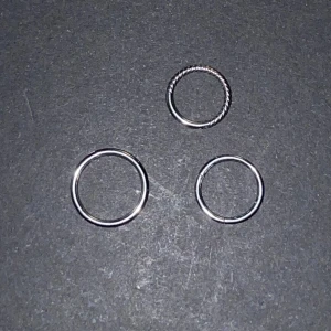Tre clickers  - Säljer tre stilrena silverringar. En av ringarna har en tvinnad design medan de andra två är släta.  De två små är 8 mm i diameter. Den stora är 10 mm. De utan design är 1 mm i ”trådstorlek”, den med design är 1,2 mm. De är rengjorda med kokat vatten. Alla för 30 kr