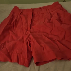 Röda shorts från Amisu - Snygga röda shorts från Amisu i en bekväm passform. Perfekta för varma sommardagar med en stilren design och praktiska fickor. Passar utmärkt till både avslappnade och mer uppklädda tillfällen.