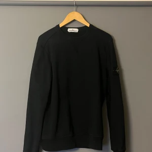Svart tröja från Stone Island - Säljer en stilren svart tröja från Stone Island. Tröjan har långa ärmar och en klassisk passform.