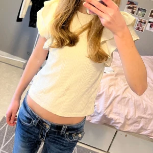 Vit ribbad topp från Zara 💞 - Säljer en söt krämvit ribbad topp från Zara med volangdetaljer på ärmarna. Toppen kommer tyvärr inte till användning och har fint skick. - Pris kan diskuteras 💗