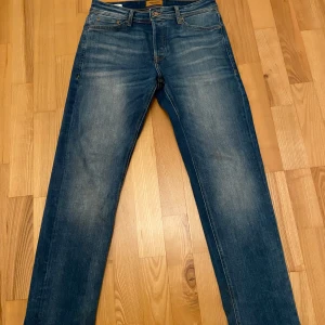 Blå jeans från Jack & Jones - Blå jeans från Jack & Jones med en slim/tapered passform. Perfekta för en avslappnad stil. Klassisk design med fem fickor och knappgylf. Inköpta i höst och i nyskick. Storlek: W29 L32.