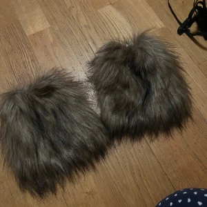 Bruna pälsliknande benvärmare  - Säljer ett par unika benvärmare med pälsliknande yta i brun nyans. De har en fluffig och mjuk textur som ger en bra känsla 