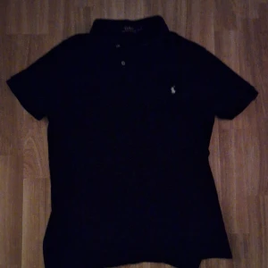  Ralph Lauren pikétröja  - Snygg svart pikétröja från Ralph Lauren, den är i perfekt skick och har ett väldigt skönt material. Storlek M men kan passa lite uppåt, hör av er vid frågor!