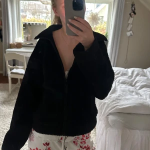 Teddyjacka hm - Mysig svart teddyjacka med dragkedja och långa ärmar. Perfekt för kyliga dagar när du vill hålla dig varm och bekväm. Enkel och stilren design som passar till det mesta.