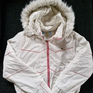 Vit Y2K-jacka med pälsluva - Säljer denna fantastiska jacka från HTH 2009 🎀 Vit med röda detaljer, pälsluva och markerad midja. Både pälsdelen och hela luvan är avtagbar, alltså tre jackor i en!  Sann till storlek (S)  Finns två små fläckar, en på framsidan och en på baksidan av ena ärmen. Dessa är obehandlade och borde gå bort i tvätt.  Pris är självklart förhandlingsbart 😊 Hör gärna av er vid frågor och glöm inte att kolla in garderoben för fler liknande plagg! 💕 