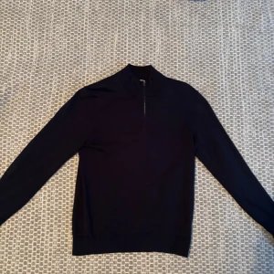 Half zip från Bläck - Snygg svart mörkblå från Bläck med halv dragkedja vid halsen. Perfekt för en stilren look. Tröjan har långa ärmar och en enkel design som passar till många tillfällen.