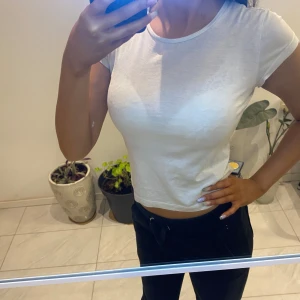 Vit kortärmad t-shirt - Säljer en enkel och stilren vit t-shirt med korta ärmar. Perfekt basplagg för alla tillfällen. T-shirten har en normal passform och är tillverkad i mjukt bomullsmaterial.