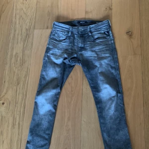 Grå jeans från Replay - Snygga grå jeans från Replay med en klassisk femficksdesign och knappgylf. De har en modern tvättad look och är perfekta för en avslappnad stil. Passar bra till både sneakers och kängor. Säljer för de är för stora för mig.