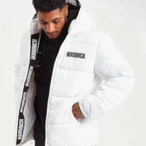 Vit pufferjacka från Hoodrich - Säljer en snygg vit pufferjacka från Hoodrich med svart text på bröstet och huvan. Jackan har en dragkedja framtill och är perfekt för kyligare dagar. Den har långa ärmar och en bekväm passform. Bara använd i en månad den är xs men är större i storleken typ som S 