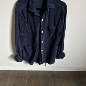 Mörkblå frotté overshirt - Snygg mörkblå overshirt i frotté tyg i strl S                      Skjortan är i bra skick 