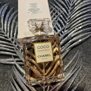 Parfym Coco Mademoiselle från Chanel - Elegant parfymflaska från Chanel, Coco Mademoiselle, med en lyxig design i glas och guld. Perfekt för den som älskar sofistikerade dofter.