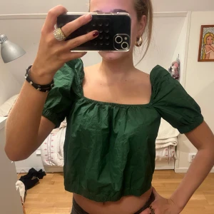 Grön topp med puffärmar  - Superfint grön topp med puffärmar som jag säljer då den inte kommer till användning. Knappt använd, lite skrynklig då den legat i garderoben ett tag. Pris kan diskuteras vid snabb affär! Passar S/M Finns fler lågmidjade jeans, trendiga tröjor och väskor billigt i min profil!