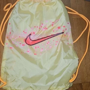 Nike fotbollsskor i beige och orange - Snygga Nike fotbollsskor i beige med svarta och orange detaljer. Skorna har en modern design med snörning och en slitstark sula för bästa grepp på planen. Helt nya fraktar snabbt