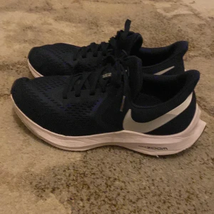 Nike runing skor - Snygga och bekväma Nike Zoom Winflo löparskor i svart med vit sula och Nike-logga. Perfekta för löpning och träning med bra dämpning och stöd. Skorna har snörning för optimal passform, dem är köpta för 1500kr och är använda 1-3 gånger tveka inte på prisförslag!