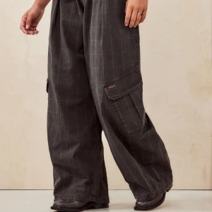  cargopants med fickor BDG BAGGY - Snygga grå cargopants med bred passform och randigt mönster. Byxorna har praktiska fickor på sidorna och en elastisk midja för extra komfort. Perfekta för en avslappnad stil. Urban outfitters bdg coccoon pants PRIS KAN DISKUTERAS💕🌟