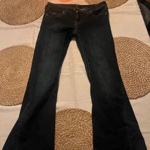Mörk blåa bootcut jeans från True Religion - Säljer mina mörk blåa True Religion jeans pågrund av att jag använder dom för lite. Dom har en liten skada längst ner på benen pågrund av att de varit för långa för mig men ingenting man tänker på. De är i storlek W29 och orginalpriset ligger på 1300 kr.