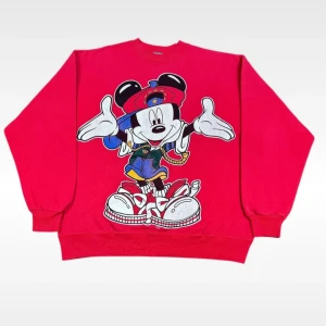 Röd sweatshirt med Musse Pigg-tryck - Cool röd sweatshirt med stort Musse Pigg-tryck på framsidan. Tröjan har långa ärmar och en avslappnad passform, perfekt för en avslappnad stil. Den är gjord i mjukt material för extra komfort. 