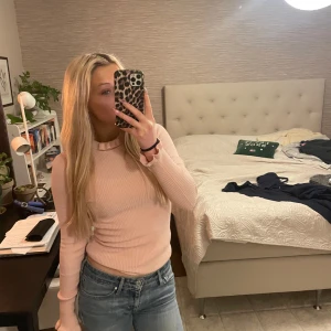 Rosa ribbad polotröja - Säljer en snygg rosa ribbad polotröja med långa ärmar. Perfekt för kyligare dagar och lätt att matcha med jeans eller kjol. Skön och stilren design som passar till många tillfällen. Aldrig använd💞💞💞
