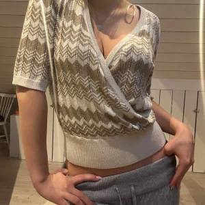 Beige omlottopp med mönster - Snygg beige omlottopp. Knappast använd är som ny! Pris kan diskuteras.