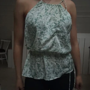 Blommig ärmlös blus - Säljer en söt blommig blus i grönt och vitt. Använd Max 2/3 gånger.