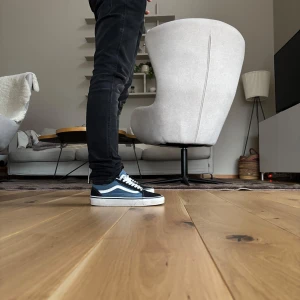 Svarta och vita sneakers från Vans - Snygga och klassiska Vans sneakers i svart och vitt. Skorna har en låg profil med vit sula och snörning. Perfekta för en avslappnad stil.