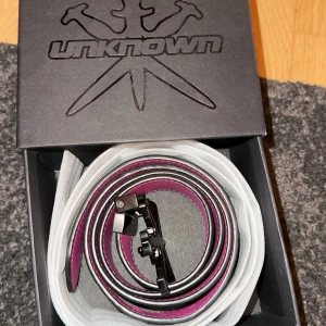  Unknown bälte  - Snyggt bälte från Unknown i svart och rosa. Bältet man kan välja vilken färg man ska ha! Väldigt unikt o coolt bälte. 85cm 