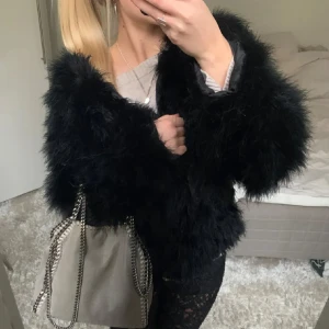 Svart pälsjacka - Säljer en snygg svart pälsjacka med långärmad design. Jackan har en fluffig och trendig look, perfekt för att hålla sig varm och stilren. Den är i en normal passform och passar bra till olika outfits. Perfekt för höst och vinter!