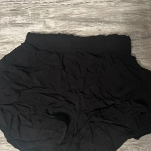 Svarta shorts - Säljer ett par svarta shorts med elastisk midja. Perfekta för en avslappnad stil. De är enkla och bekväma, idealiska för vardagsbruk.