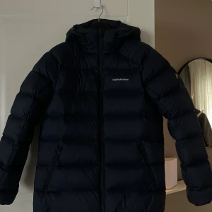 Dunjacka från Peak Performance - Marinblå varm och skön dunjacka, inte amvönd särskilt mycket och är i bra skick. 
